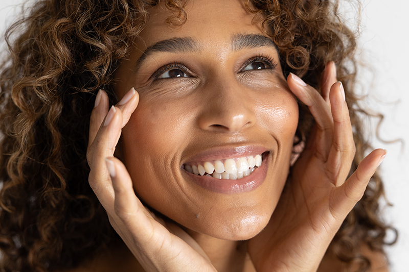 Woman smiling touching her face